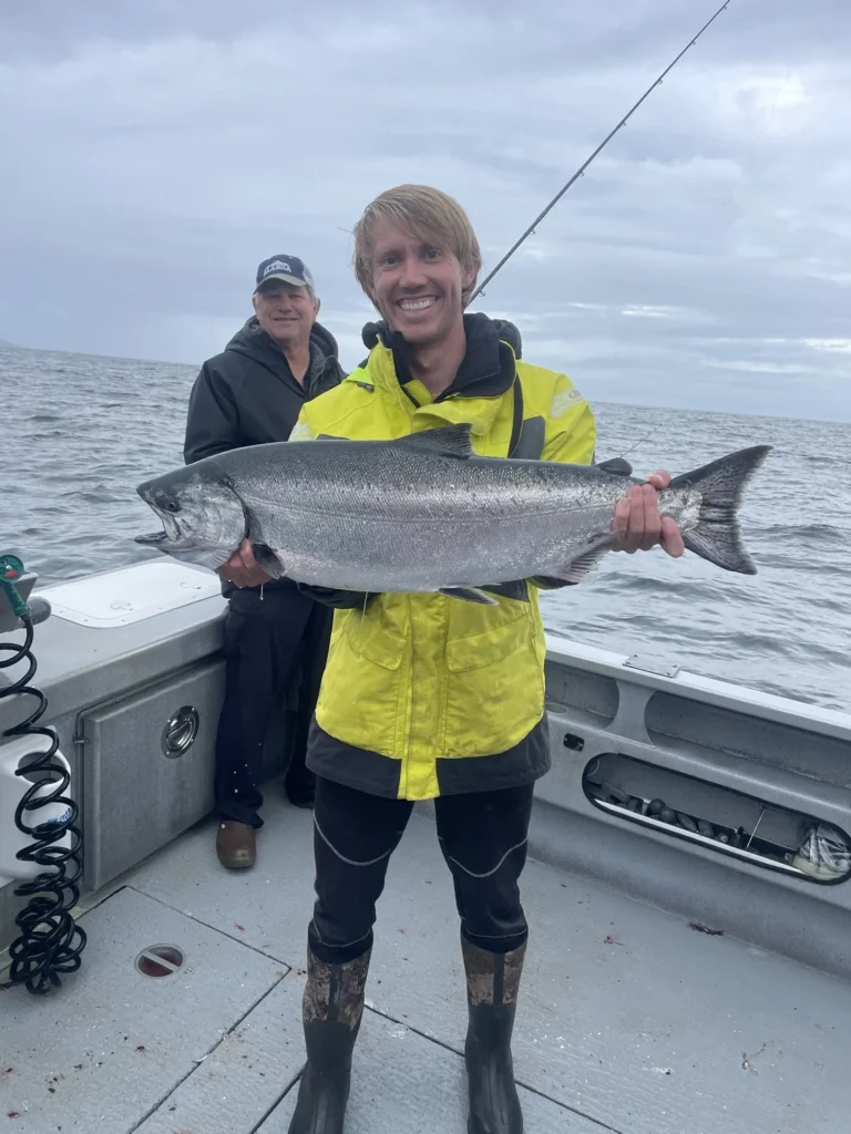 Man Holding a Fish on a boat in the ocean